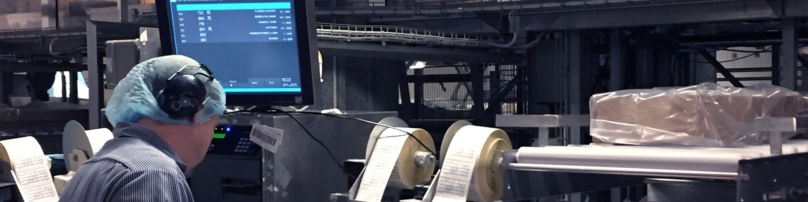 Production-line operator beside a control display